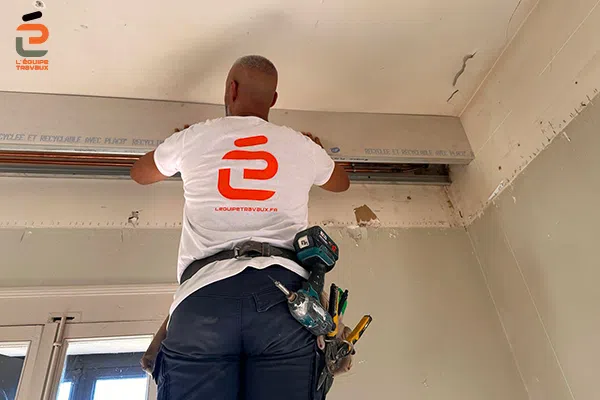 Artisan plaqiste de l'Équipe Travaux en train de créer un coffre d'habillage de canalisation de chauffage en placoplatre
