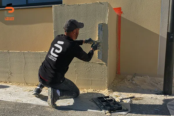 Artisan façadier de l'Équipe Travaux en train d'appliquer un enduit à la chaux pour une maison