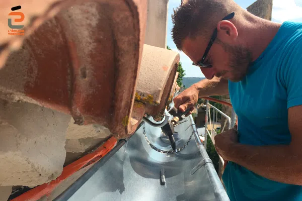 Artisan zingueur de l'Équipe Travaux en train de souder une gouttière en zinc